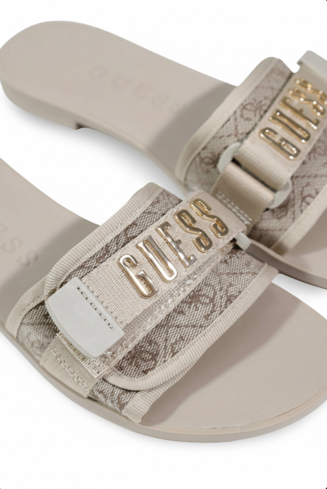 Sandali bassi Guess Elyze, tomaia in 100% poliestere con stampa monogramma e fibbia logo dorata; sandali slide estivi con suola sottile e dettagli hardware gold. Vista logo