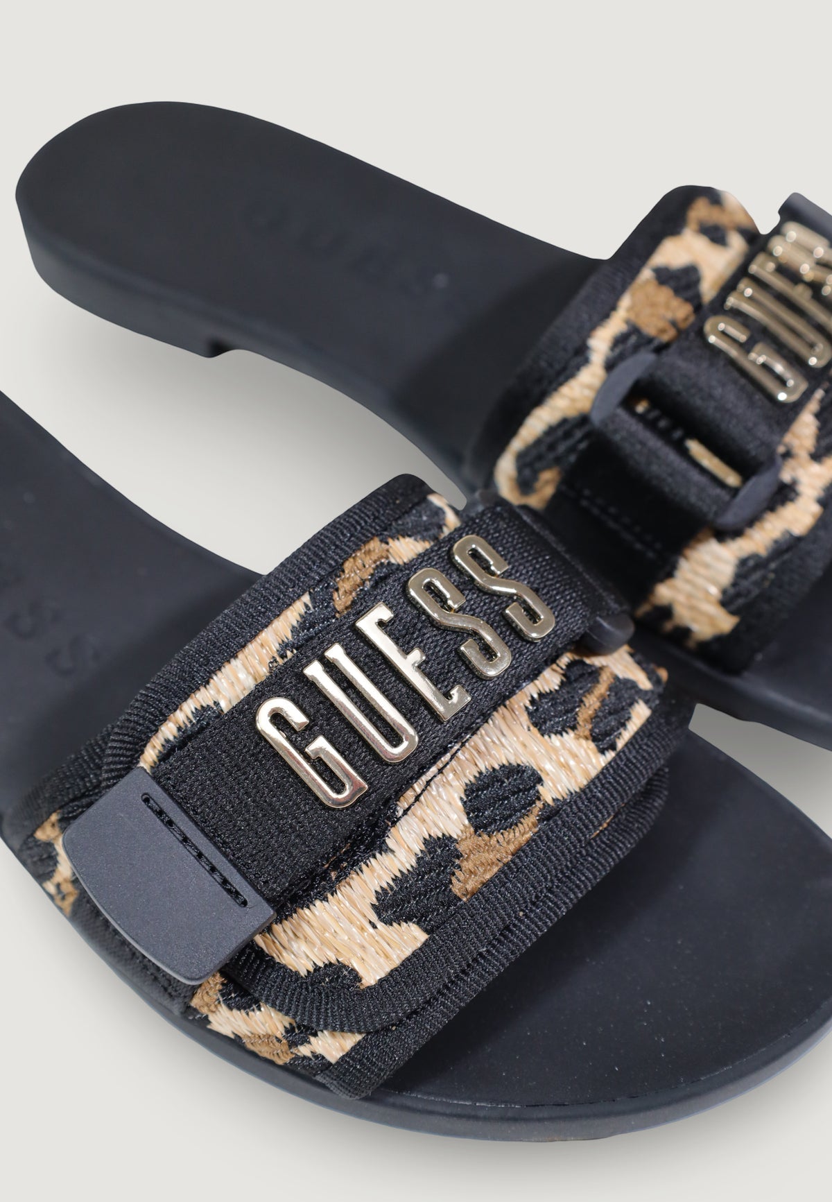 Guess FLJEL5 FAB03, sandali neri bassi da donna con fascia logata; fibbia metallica dorata, struttura leggera e flessibile, stile contemporaneo e chic. Vista logo