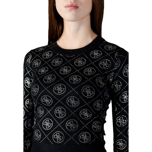 Maglione Guess 4G Strass; Misto Lana Riciclata. Vestibilità regular, maniche lunghe, logo gioiello. Maglia donna calda, luminosa ed ecosostenibile. Colore nero vista frontale Dettaglio logo strass
