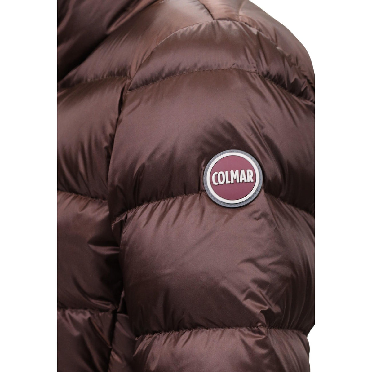 Piumino Colmar donna marrone scuro sciancrato. Giaccone invernale svasato idrorepellente con collo alto, imbottitura in piuma d'oca naturale certificata RDS, tessuto riciclato e patch logo Colmar Originals.