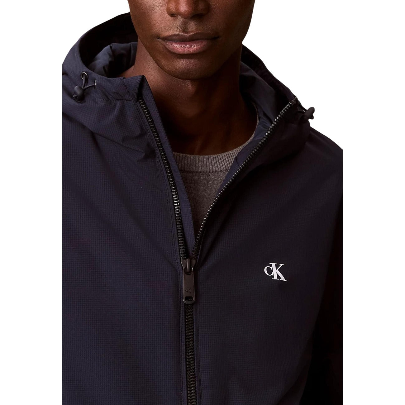 Giacca a vento Calvin klein blu navy Realizzato al 100% in poliestere riciclato, Il logo CK ricamato sul petto, la chiusura frontale con zip e il cappuccio regolabile Vista frontale dettaglio logo e cerniera