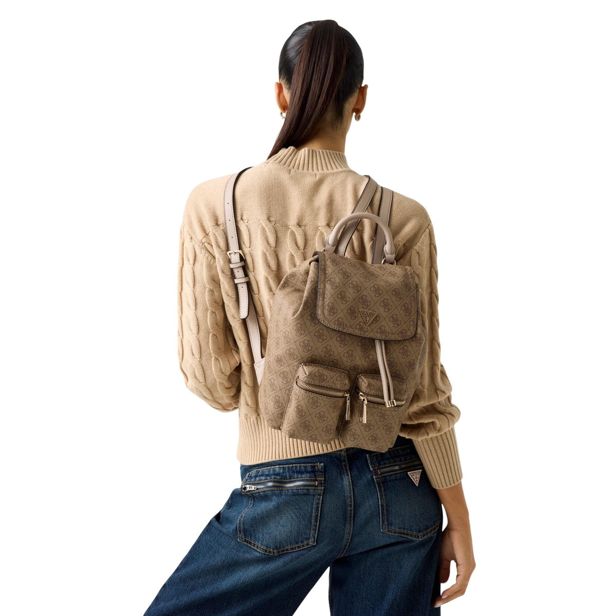 Zaino beige donna Guess MANHATTAN II FLAP BACKPACK. Realizzato interamente in poliuretano di alta qualità, texture con logo Guess in rilievo. patta con chiusura magnetica e dettagli metallici dorati Vista frontale indossato da modella