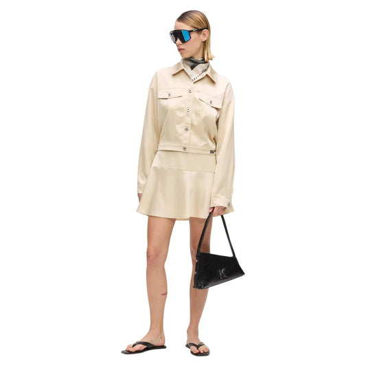 Minigonna Raso Trapezio; 100% Poliestere. Finitura iridescente, zip invisibile, logo ricamato. Gonna corta donna elegante e luminosa per la stagione PE26. Colore beige vista frontale Figura intera