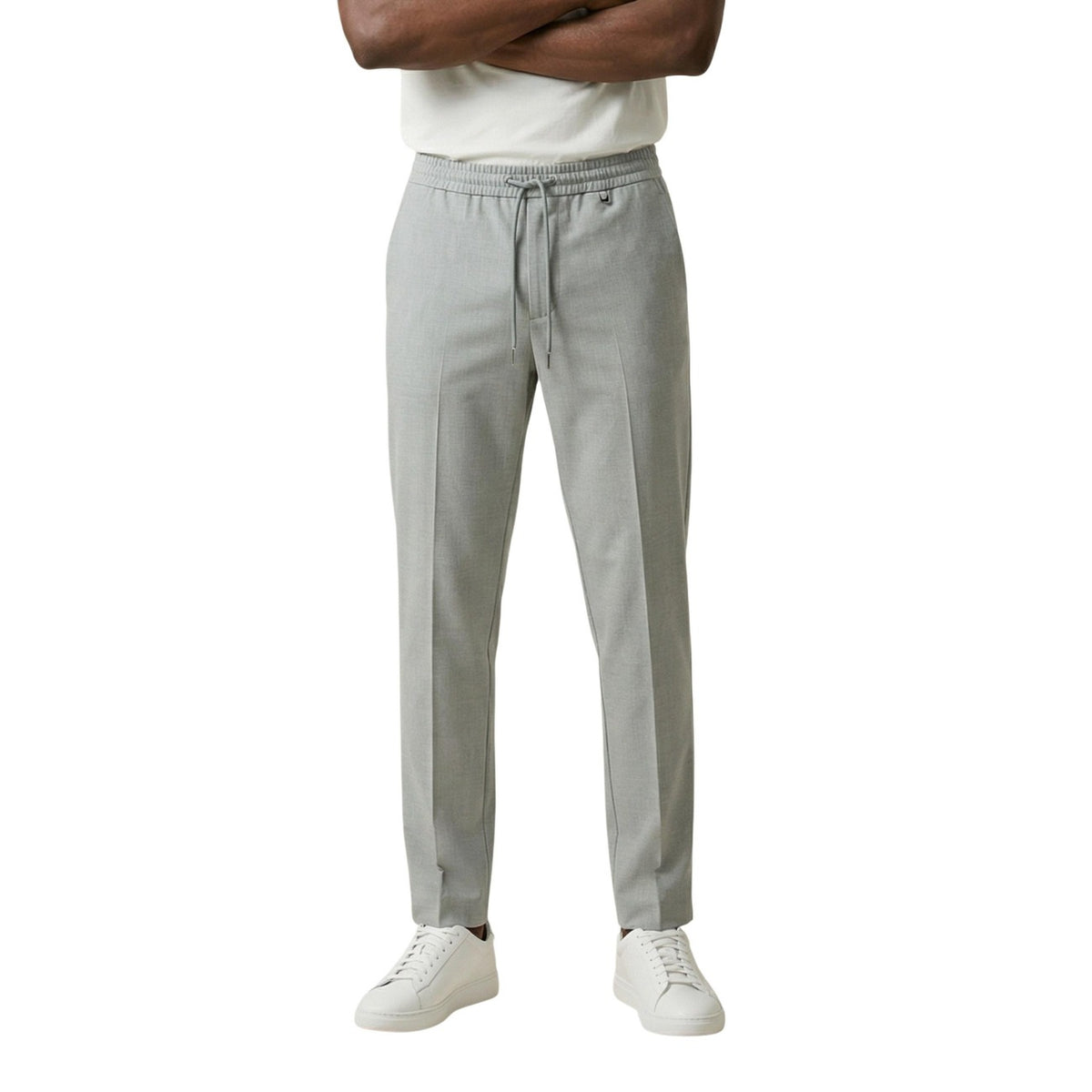 Pantaloni Antony Morato Neil; Regular Fit, tessuto elasticizzato, vita con coulisse. Piega centrale, logo metallico, stile hybrid-formal. Versatili, confortevoli e antipiega. Colore grigio vista frontale