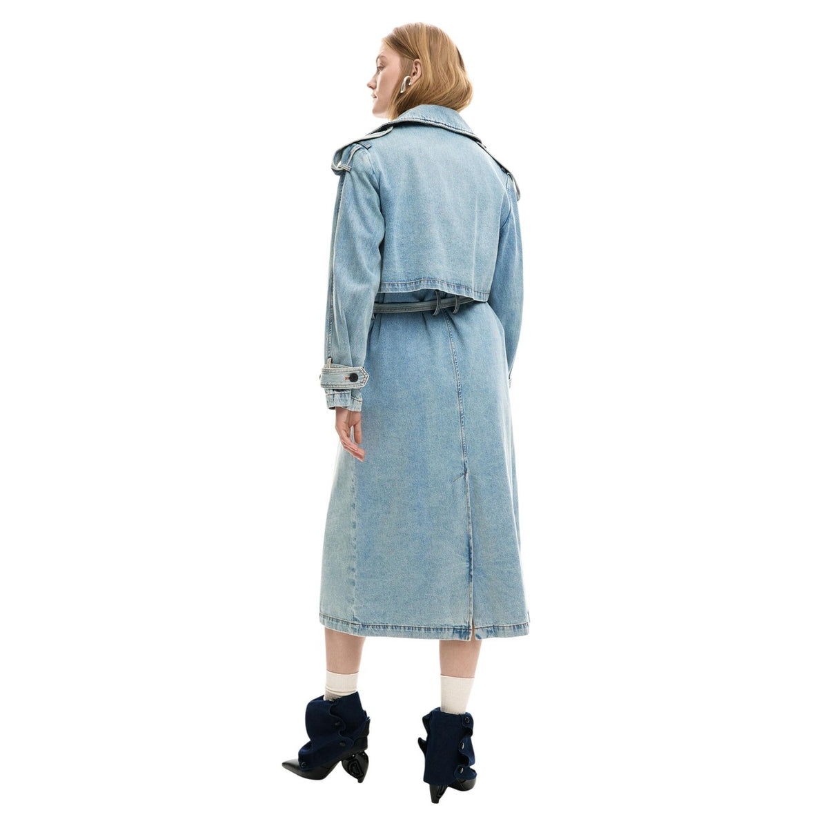 Giacca lunga stile trench in tessuto denim, con revers, chiusura con bottoni e cintura rimovibile. Indossata da modella figura intera vista posteriore
