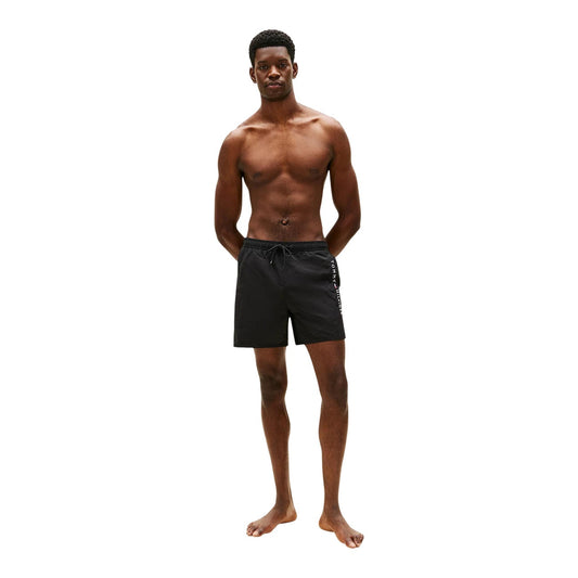 Costume Shorts Tommy Hilfiger; Nero. 100% Nylon. Lunghezza media (40,5 cm), chiusura con lacci, tasca laterale con zip. Dettagli iconici e logo ricamato, lavabile a 30°C. Figura intera
