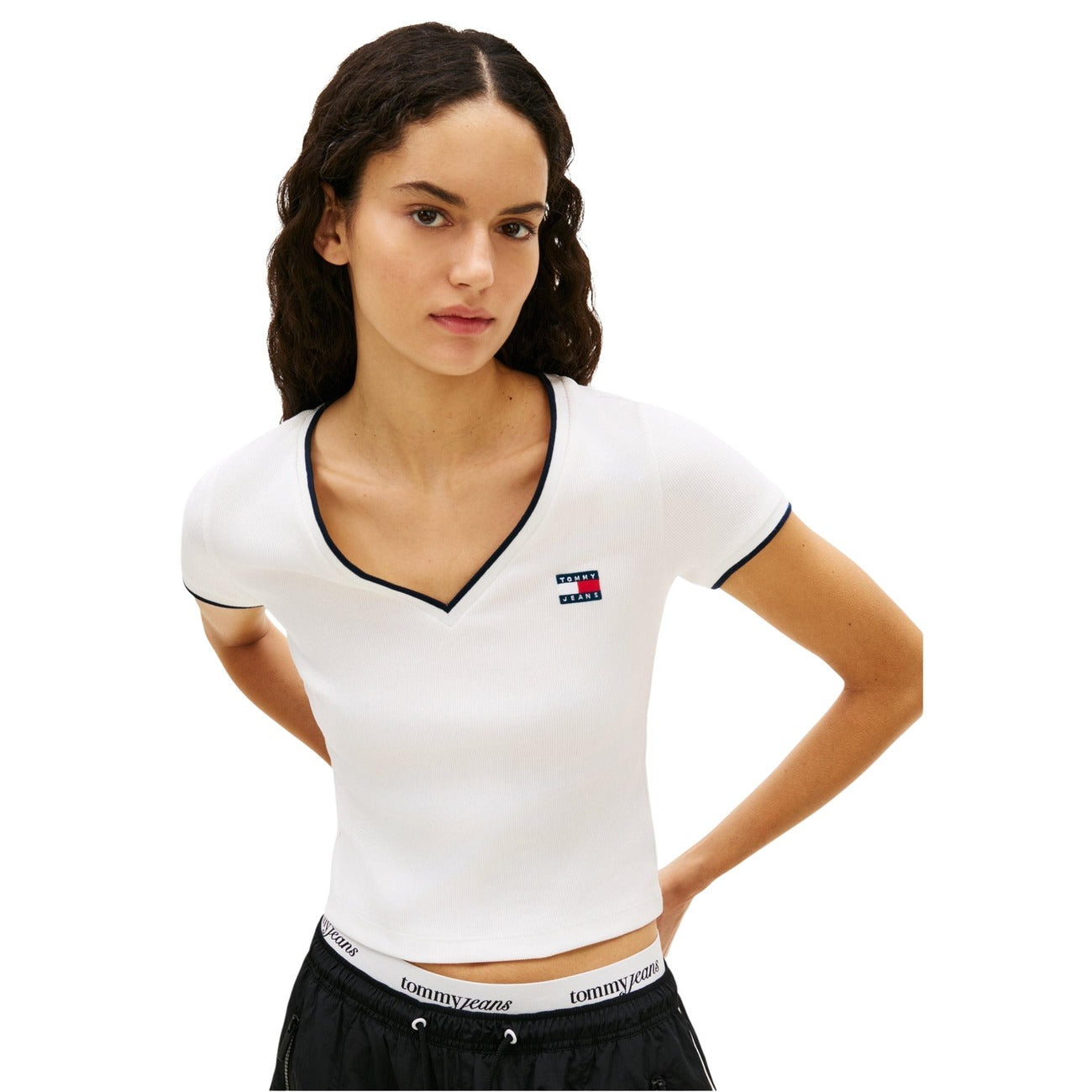 Tommy Jeans DW0DW22275; Top beige in cotone organico, scollo a V, maniche corte. Il basic sostenibile ed elegante per la stagione Primavera/Estate. Colore bianco. Vista frontale Indossata da modella