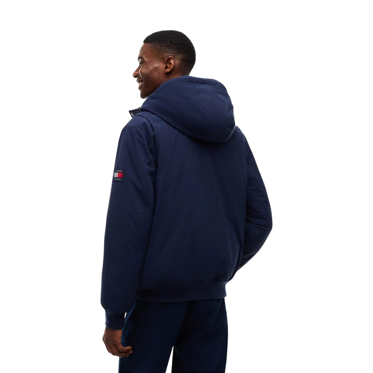 Bomber blu uomo Tommy Jeans DM0DM22032C1G. Giambotto imbottito blu navy antivento e idrorepellente con cappuccio, polsini a coste e patch Tommy.