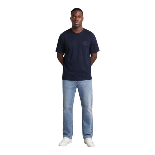 T-shirt Blu navy Calvin Klein; Logo Goffrato in rilievo. 100% Jersey di Cotone. Vestibilità regolare, girocollo a costine, morbidezza premium. Stile minimalista e ricercato. Vista frontale figura intera