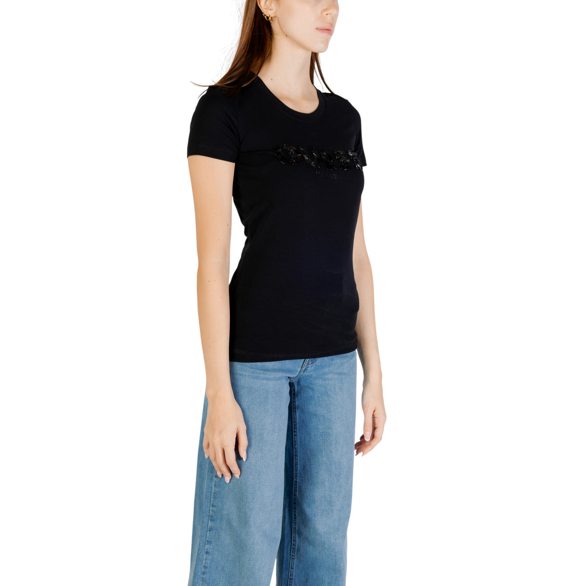 T-shirt nero Slim Girocollo Donna Guess Logo Paillettes; Tessuto 95% cotone biologico e 5% lycra a maniche corte. Scritta Guess frontale con paillettes luminose ricamate, stile casual-luxury ecosostenibile. Vista frontale laterale