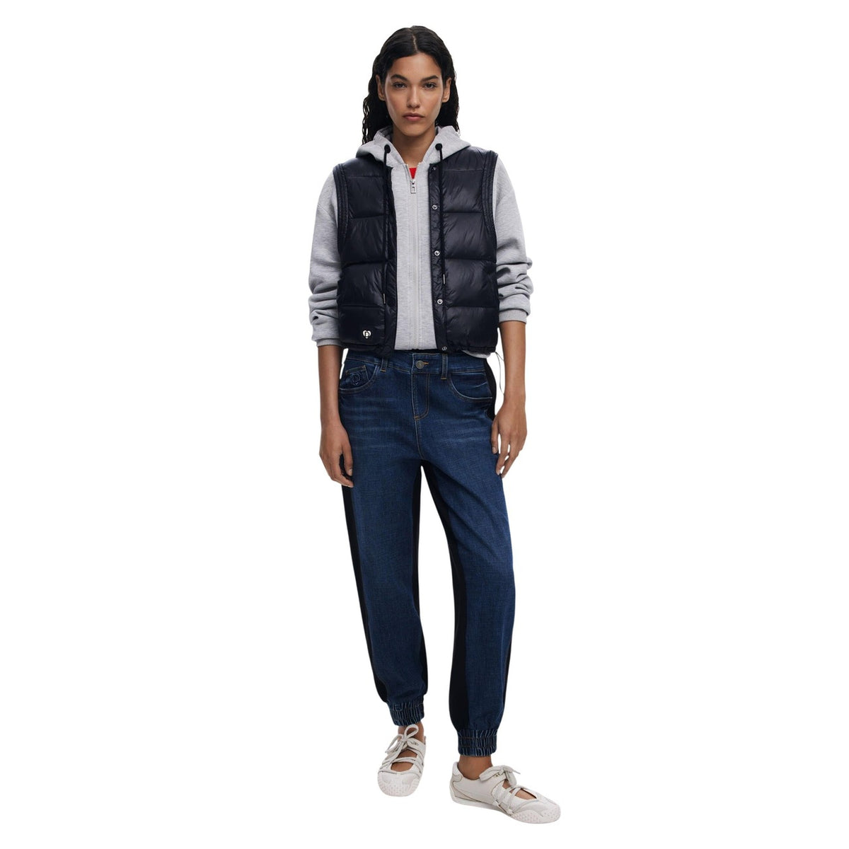 Felpa e Gilet 2-in-1 AW25; imbottitura termica, chiusura zip e bottoni, cappuccio regolabile. Il capo tecnico e stiloso disegnato a Barcellona. Vista frontale figura intera