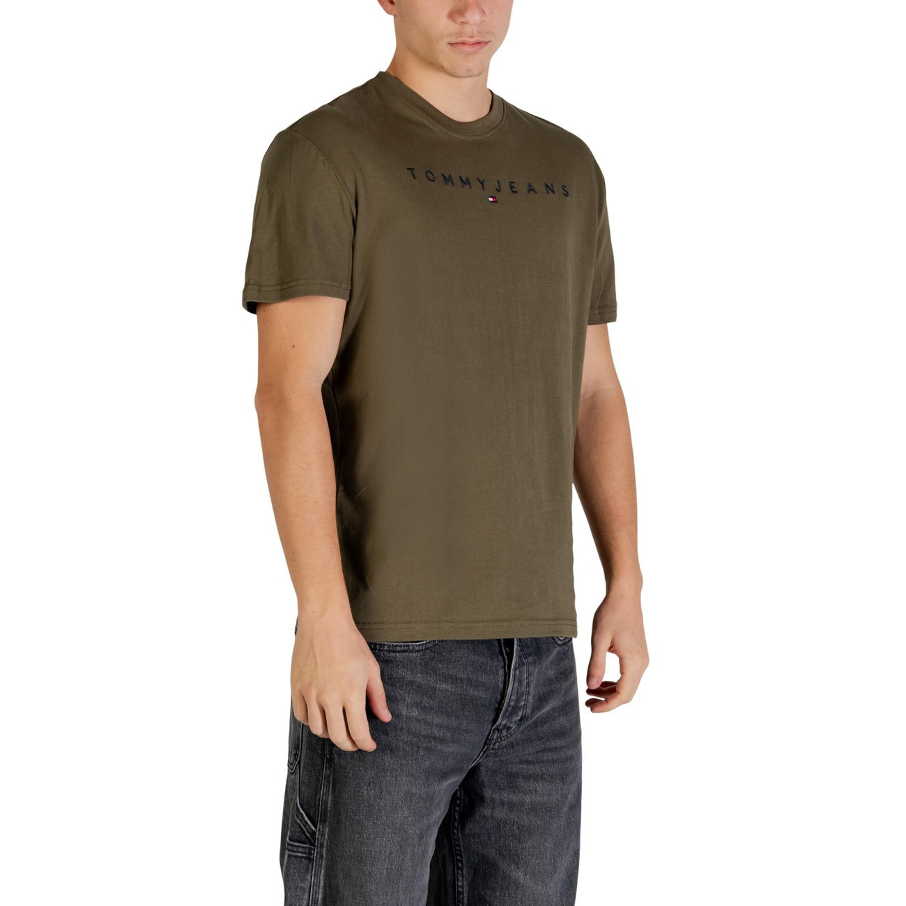 T-shirt Tommy Jeans Linear Logo; 100% Cotone Rigenerato. Regular fit, girocollo, stampa frontale. Maglia uomo eco-friendly, fresca e resistente per outfit quotidiani. Colore verde vista frontale Laterale