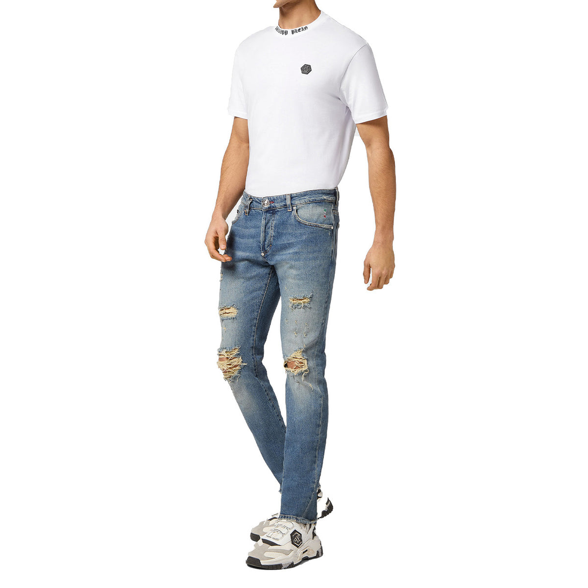 Jeans Philipp Plein BO_1480; Blu Stone Washed. 99% Cotone, 1% Elastan. Vestibilità Skinny, dettagli strappati e usurati, patch in pelle con logo PP Hexagon. Qualità sartoriale Made in Italy. Indossato da modello