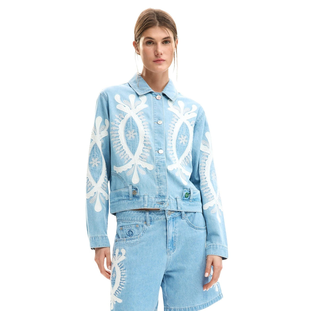 Giacca di jeans in cotone 100% con ricami in tonalità blu e design a taglio regular. Colletto a camicia e maniche lunghe con chiusura con bottone ai polsini. Chiusura frontale con bottoni e cuciture visibili. Indossata da modella vista frontale