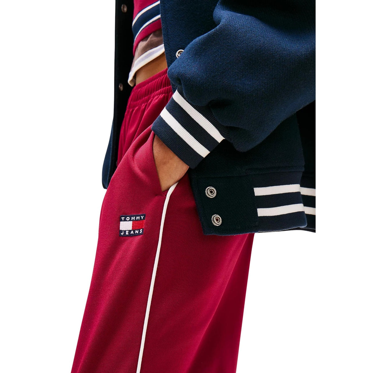 Pantaloni Tommy Hilfiger Jeans DW0DW22633; 89% Poliestere Riciclato. Gamba ampia, vita elastica, logo TH. Pantaloni donna athleisure, flessibili e traspiranti Colore bordeaux rosso. Vista laterale dettaglio logo