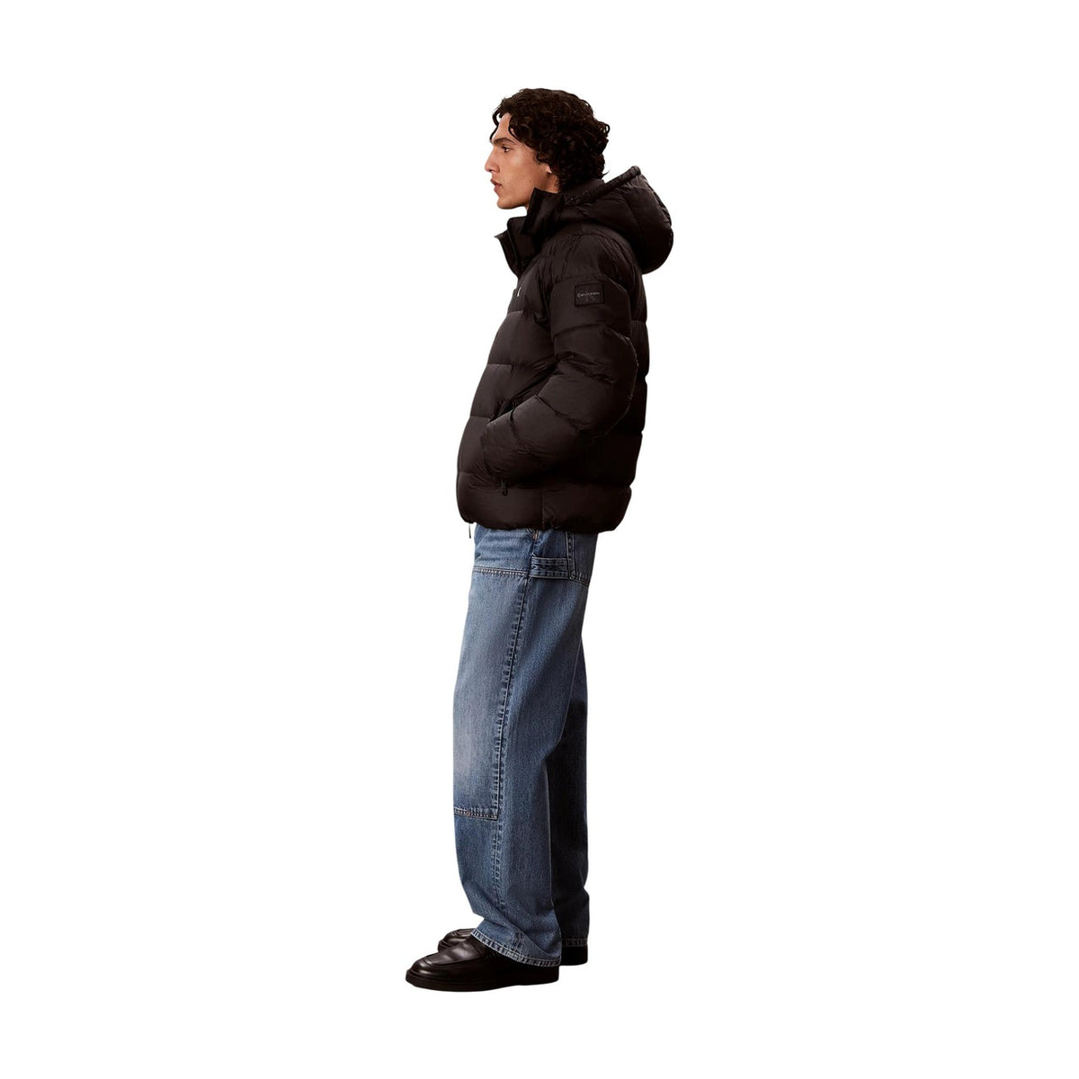 Piumino Calvin Klein uomo nero LV04RG515G. Giaccone invernale pesante in poliestere riciclato ecosostenibile con logo cK ricamato, cappuccio, tasche laterali oblique e vestibilità regolare normal fit.