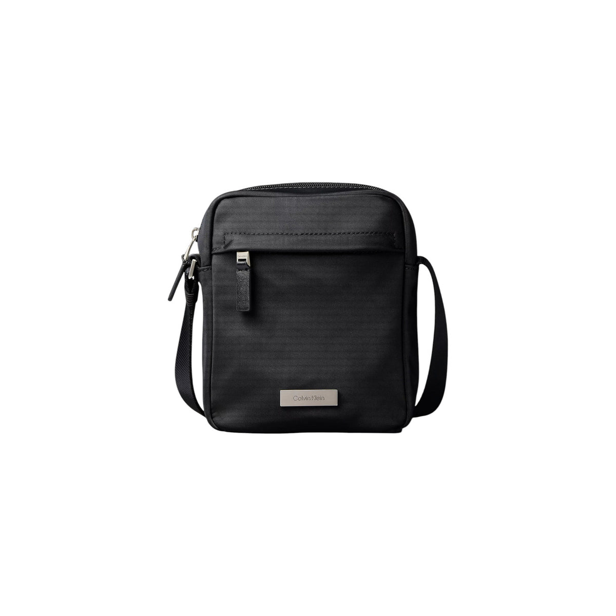 Borsa Tracolla Uomo Calvin Klein Clean Reporter; Nero. 100% Nylon riciclato ecosostenibile, doppia chiusura con zip, tracolla regolabile in tessuto e divisori interni. Dimensioni compatte (16x20 cm), stile minimalista e leggero. Vista frontale