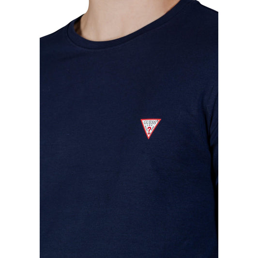 Guess LS Core Tee; 95% cotone, 5% elastan, logo discreto al petto. La t-shirt a maniche lunghe essenziale dal taglio contemporaneo. Colore blu scuro. Vista frontale Dettaglio logo