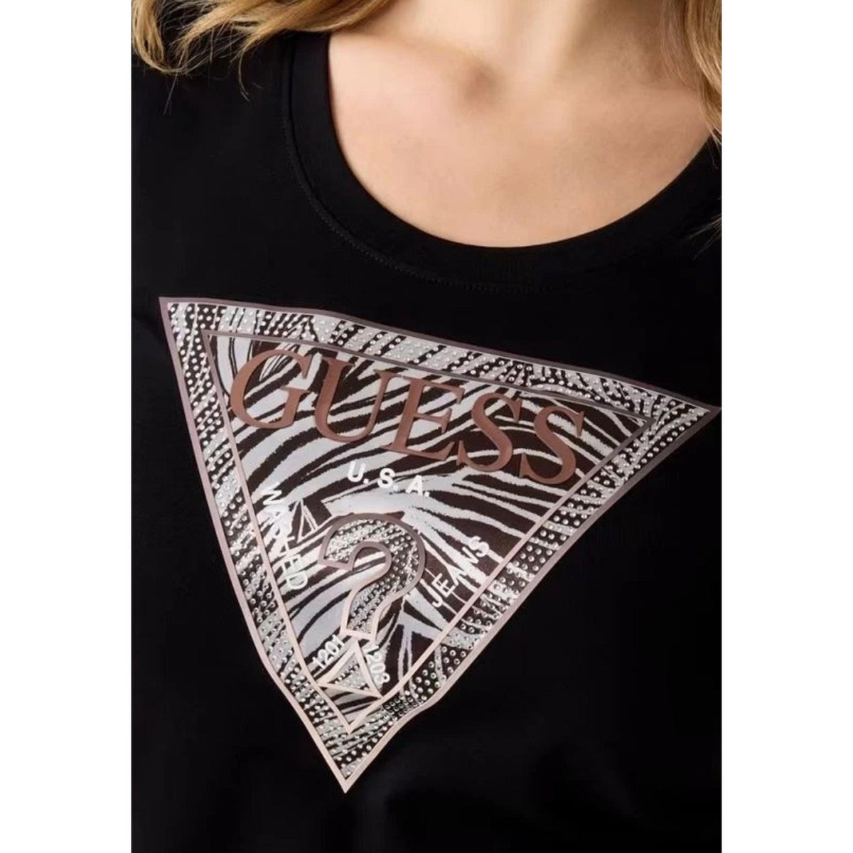 T-shirt Guess Nera Logo Zebra; 95% Cotone, 5% Elastam. Modello slim fit, maniche corte, scollo tondo. Logo a triangolo con stampa zebrata, tessuto leggero e flessibile. Dettaglio logo