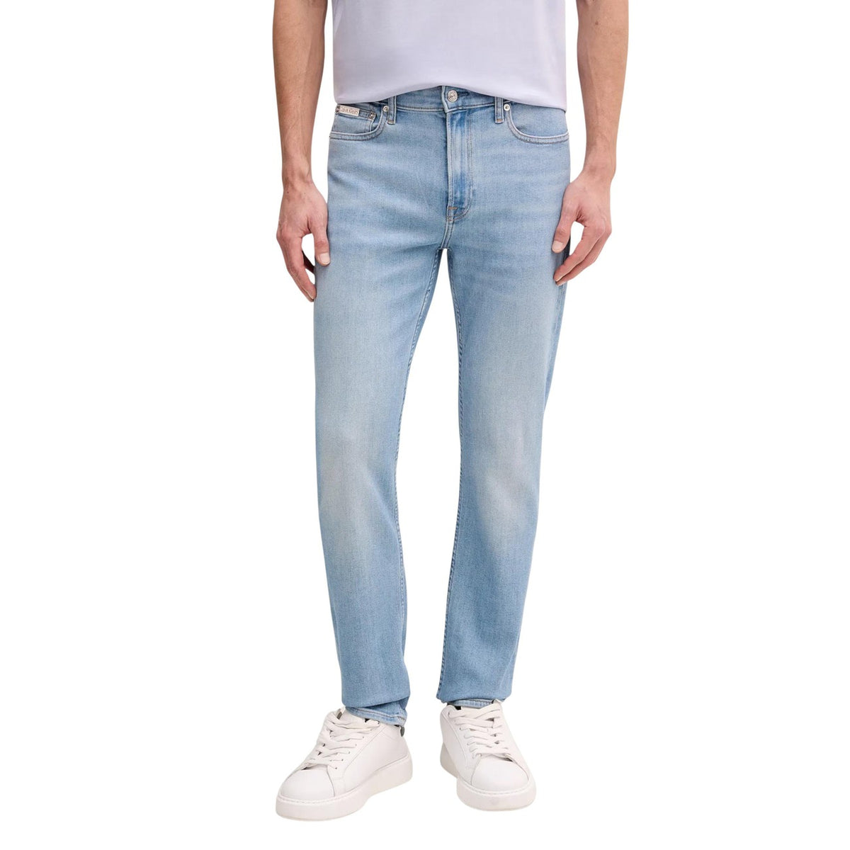 Jeans Slim Calvin Klein; Blu. 85% Cotone, 13% Poliestere Riciclato, 2% Elastan. Vita media, 5 tasche, chiusura con cerniera. Vestibilità asciutta e tessuto elasticizzato sostenibile. Vista frontale