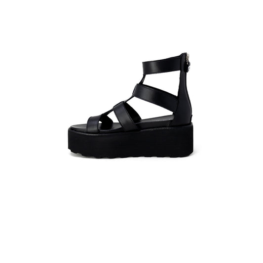 Sandali Platform Cult Nancy; Nero. Pelle e poliuretano, tacco 6 cm, suola dentellata. Chiusura con zip posteriore, logo metallico laterale. Stile grintoso e moderno.