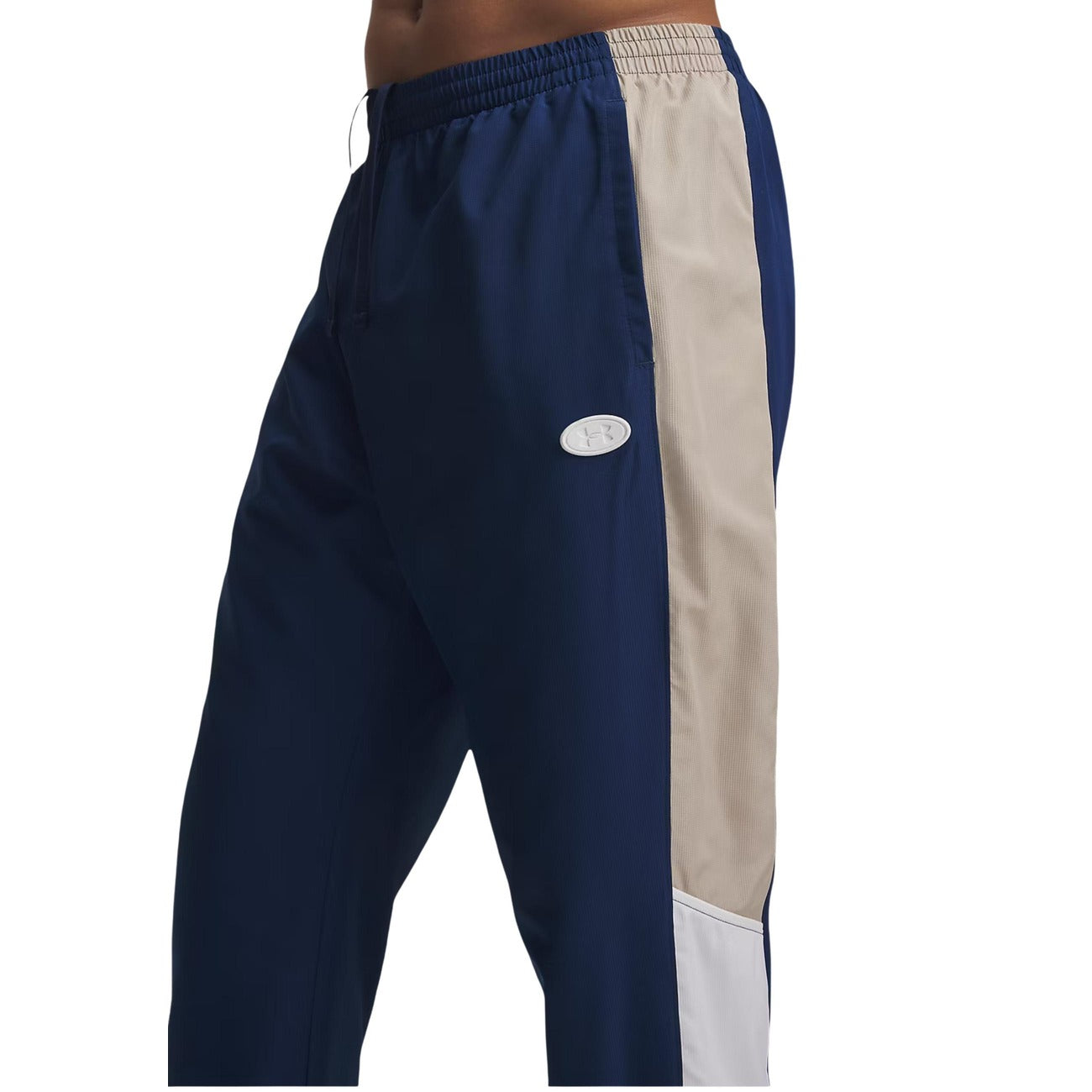 Pantaloni Under Armour uomo blu modello UA RIVAL WOVEN CB PANTS. Pantaloni lunghi da tute sportive e allenamento in poliestere con bande a contrasto colour block, vita elastica e tasche con cerniera, pantalone casual athleisure per la mezza stagione.
