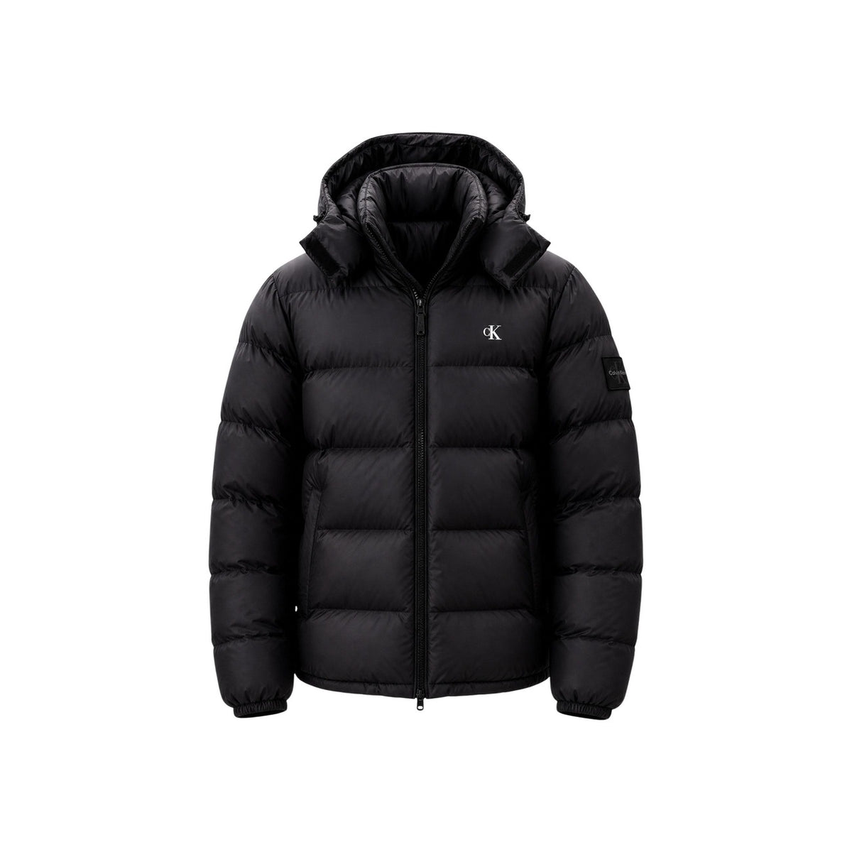Piumino Calvin Klein uomo nero LV04RG515G. Giaccone invernale pesante in poliestere riciclato ecosostenibile con logo cK ricamato, cappuccio, tasche laterali oblique e vestibilità regolare normal fit.