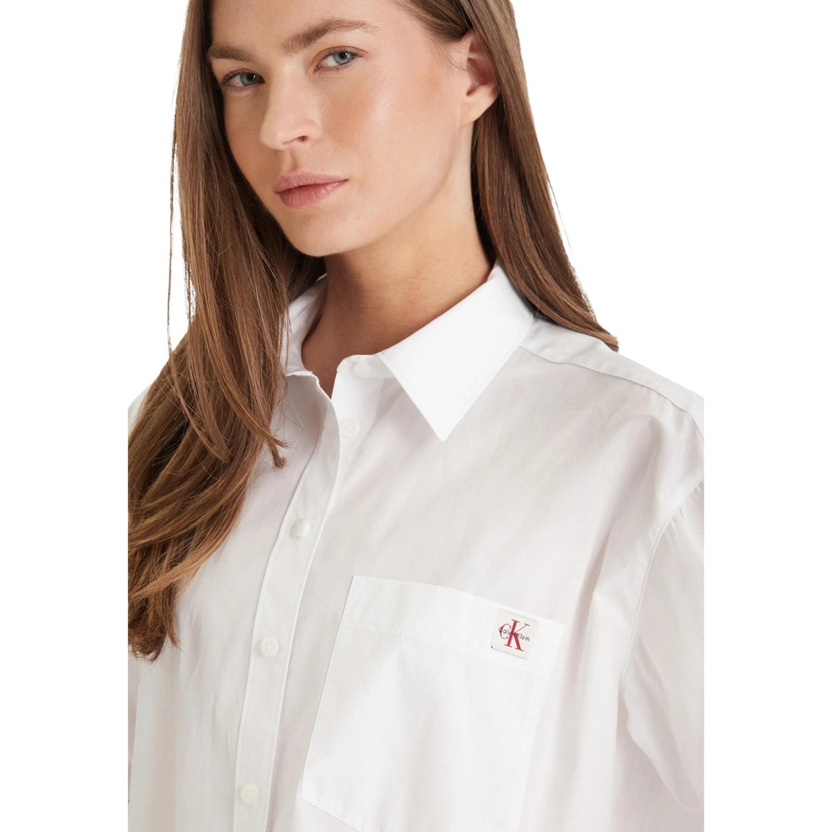 Calvin Klein Jeans LV047F147G; 100% cotone, taglio rilassato, taschino logato. La camicia in denim essenziale per un guardaroba senza tempo. Colore bianco. Vista frontale Dettaglio logo taschino