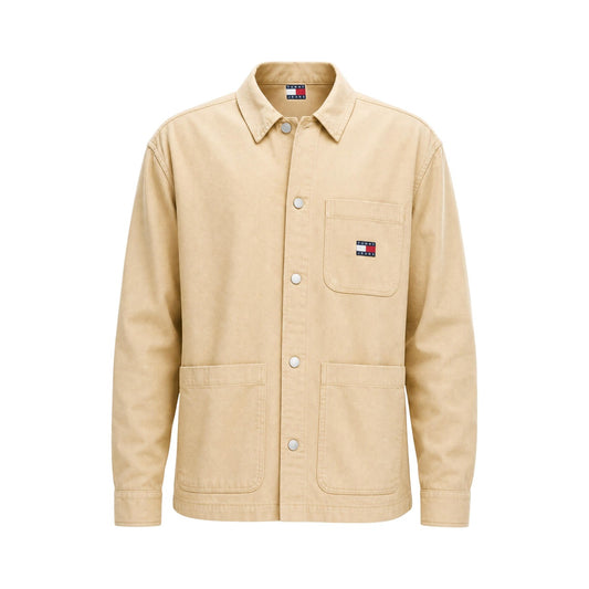 Camicia Beige Tommy Jeans; Utility Style. 100% Cotone Rigenerato. Doppia tasca frontale, logo ricamato, vestibilità regolare. Robusta, versatile e attenta all'ambiente. Vista stesa frontale