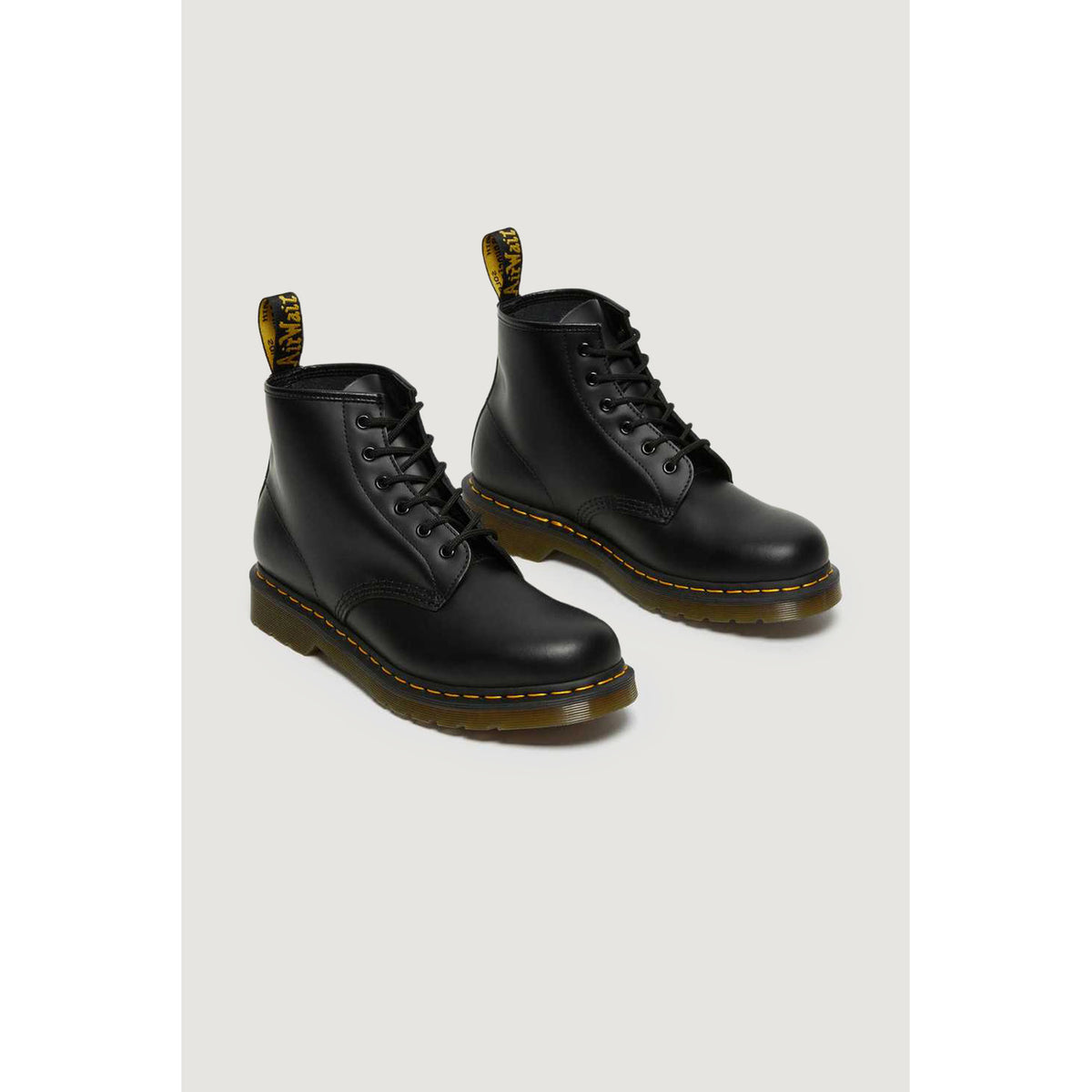 Anfibi Dr Martens 101 uomo pelle Smooth nero. Stivaletti bassi a 6 fori in pelle liscia resistente, lavorazione con guardolo Goodyear termosaldato, impunture gialle e suola in gomma ammortizzata.