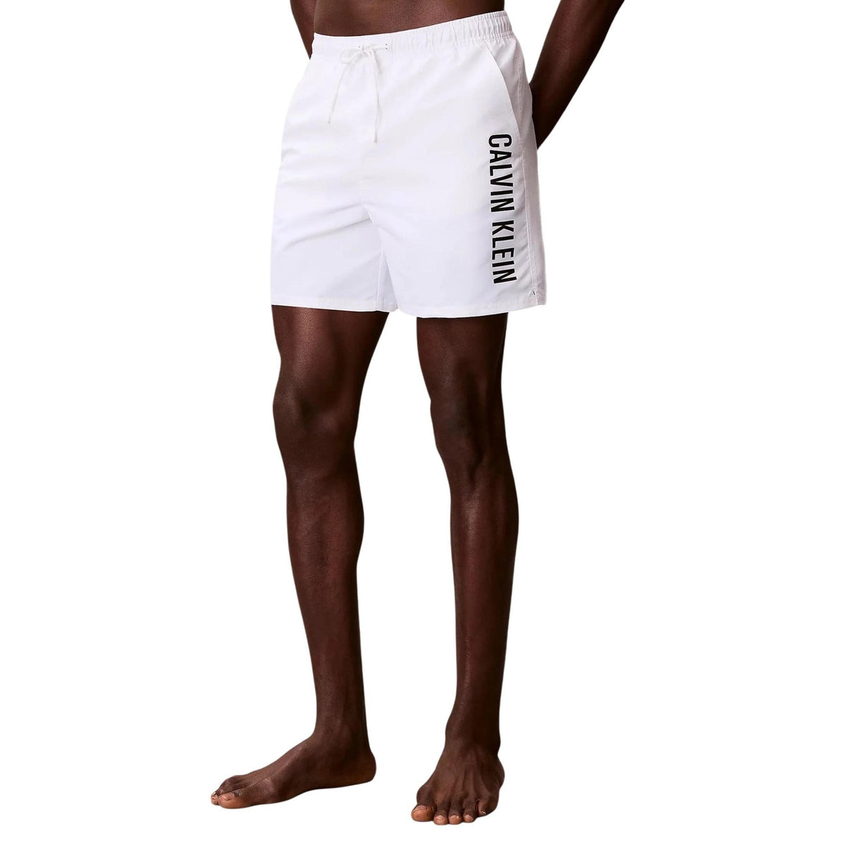 Calvin Klein Intense Power Swim Shorts; 100% poliestere, interno gamba 13 cm, logo macro. Il costume sportivo premium resistente all'acqua. Colore bianco. Vista laterale frontale