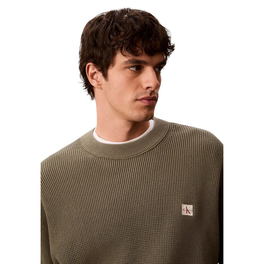 Maglione Girocollo Uomo Calvin Klein Jeans; Verde. 100% Cotone leggero lavorato a nido d'ape (waffle), vestibilità regolare e logo sul petto. Ideale per le mezze stagioni, stile casual-chic. Dettaglio