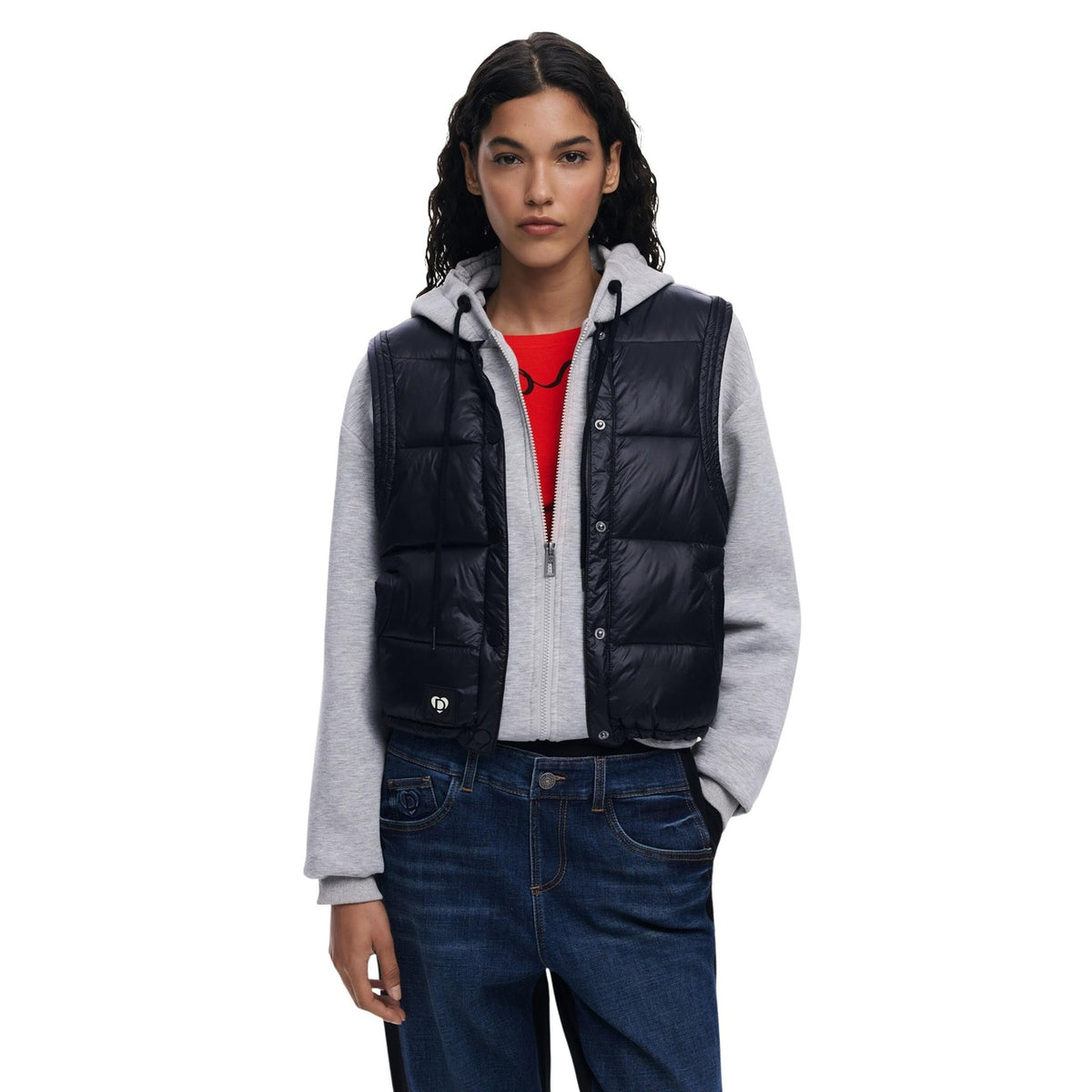 Felpa e Gilet 2-in-1 AW25; imbottitura termica, chiusura zip e bottoni, cappuccio regolabile. Il capo tecnico e stiloso disegnato a Barcellona. Vista frontale