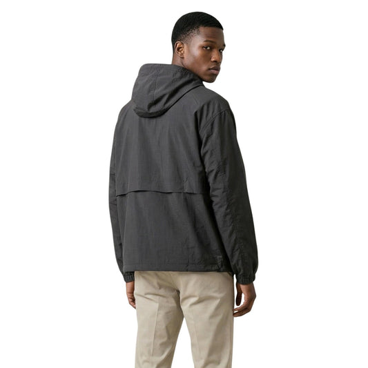 Giacca New Balance Ripstop; 100% nylon antistrappo, cappuccio regolabile. Zip con patta, 3 tasche esterne, polsini elastici. Leggera, antivento e resistente per le mezze stagioni. Vista posteriore