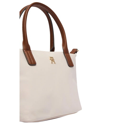 Borsa Tommy Hilfiger Nylon Monogram Tote; Chiusura con zip, tracolla rimovibile, placchetta TH dorata. Materiale leggero e resistente, capienza 7 l. Design iconico e funzionale. Colore bianco vista Laterale