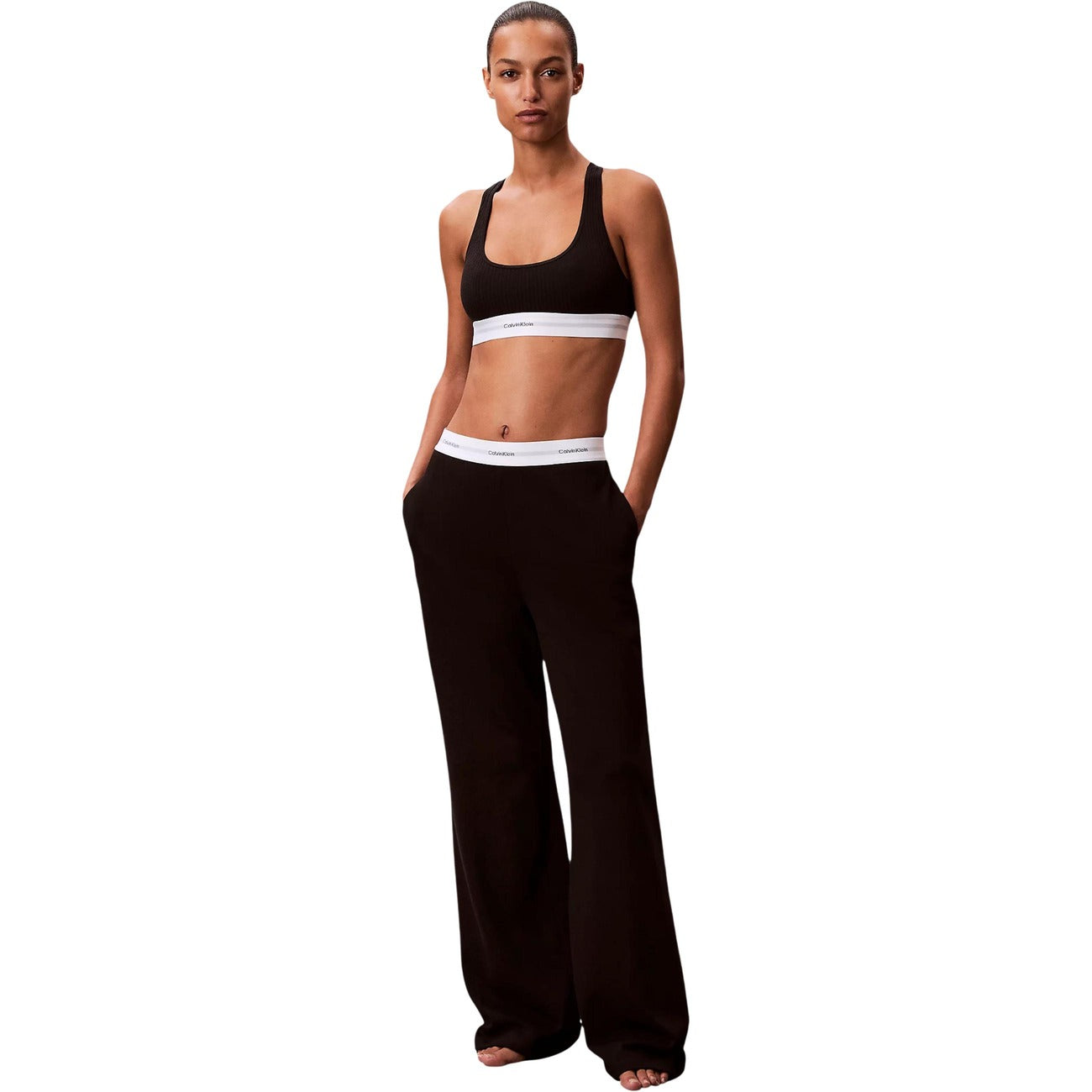 Pantaloni pigiama Calvin Klein donna neri modello LOGO JERSEY PANT. Pantalone lungo da notte e loungewear in maglia di cotone a coste tinta unita con tasche laterali e fondo con risvolto, dotato di fascia elastica logata in vita, stile casual sportivo e minimale.
