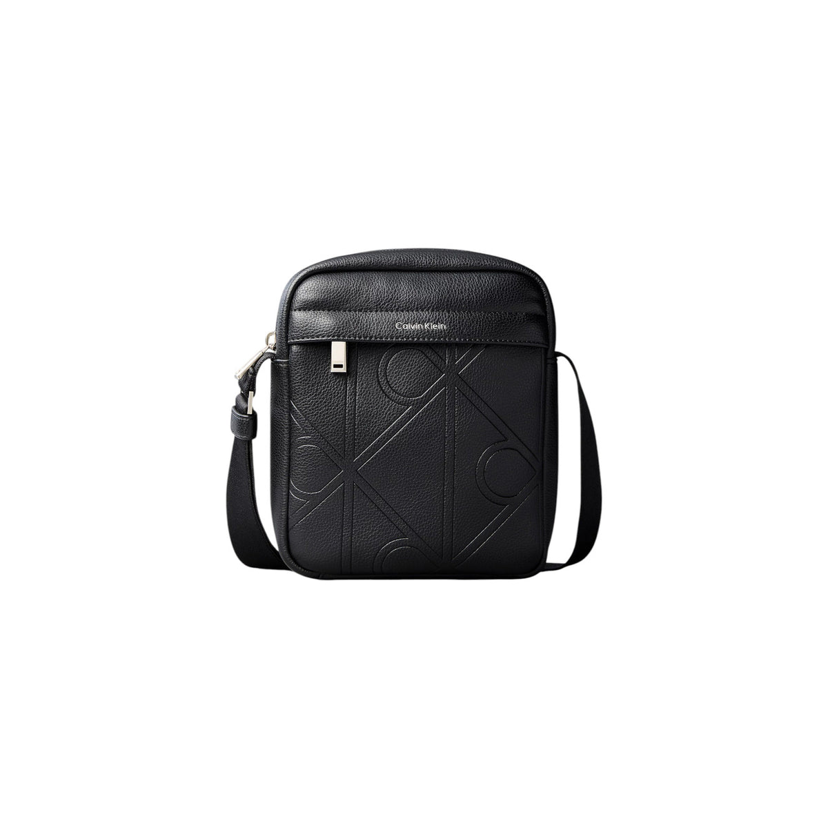 Borsa Tracolla Uomo Calvin Klein Reporter; Nero. 100% Poliuretano effetto pelle martellata con loghi incisi, chiusura zippata, tracolla regolabile. Dimensioni compatte (16x20 cm), stile minimal e moderno 4 stagioni. Vista frontale