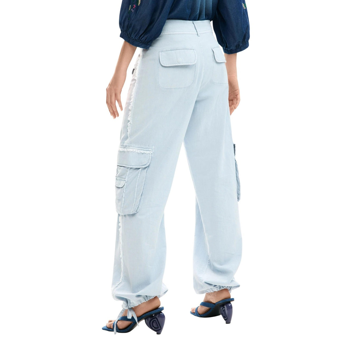 Cargo Pants SS26; fit utility, tasche laterali maxi, vita e fondo regolabili con coulisse, finiture sfrangiate. Il pantalone cargo versatile, tecnico e stiloso. Colore azzurro vista posteriore