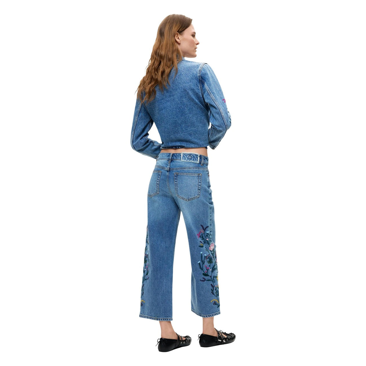 Jeans Desigual donna modello DENIM_BRIDGE. Pantaloni in denim blu lavato stile culotte a gamba larga con ricami a fiori colorati, realizzati in cotone sostenibile BCI leggermente elasticizzato, stile casual e boho-chic per la collezione autunno inverno.