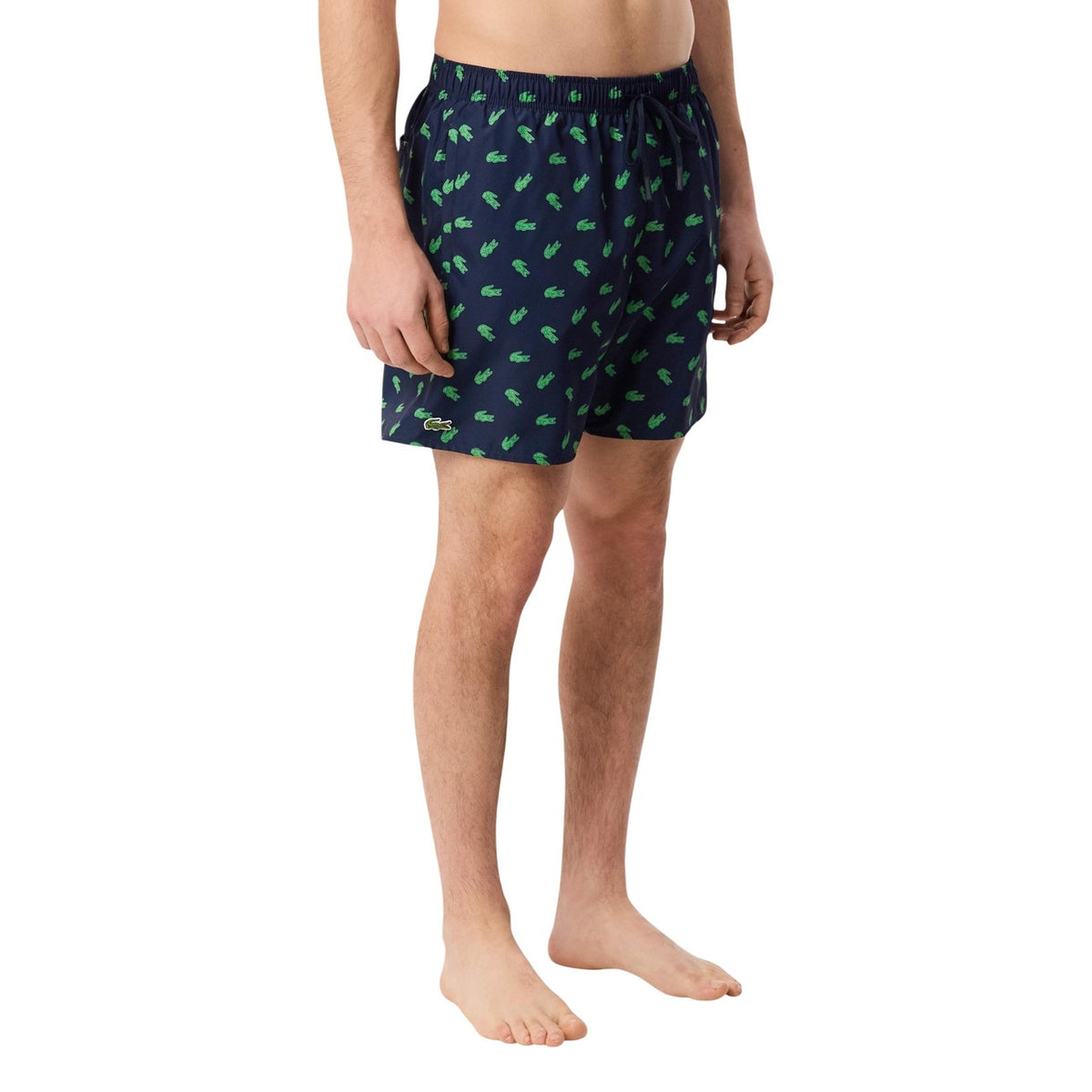 Costume Lacoste uomo Croco Print; poliestere riciclato, taglio 42 cm, slip interno in mesh. Stampa all-over, tre tasche, asciugatura rapida. Include pochette in tessuto riciclato.
