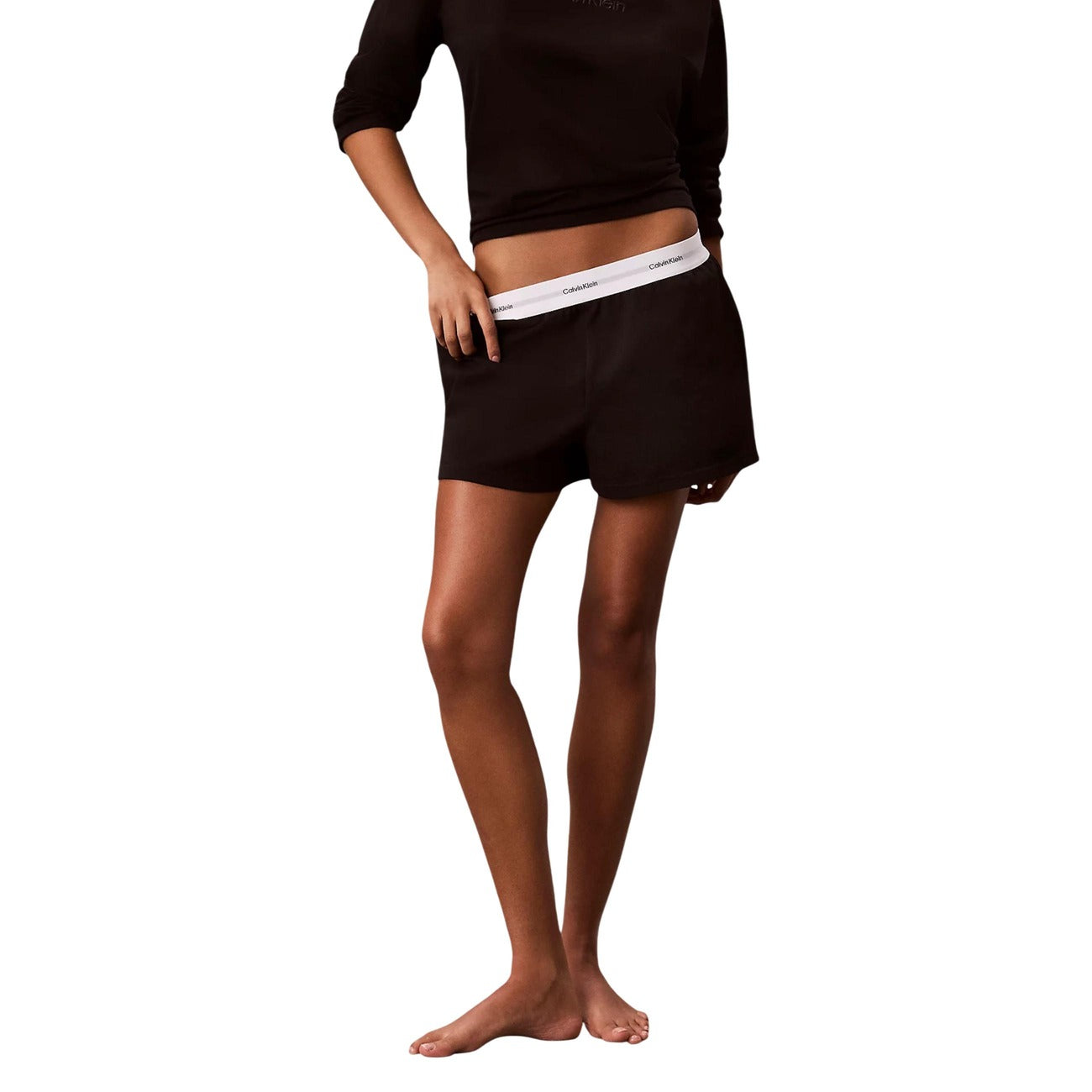 Pantaloncini pigiama Calvin Klein donna nero. Shorts da notte e loungewear in morbido jersey di cotone a tinta unita con tasche laterali e spacco sull'orlo, caratterizzati dalla classica fascia elastica logata in vita, stile sportivo e minimalista.