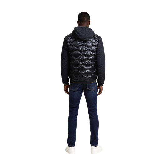 Giubbotto uomo Blauer nero Albert 26WBLUC08068. Piumino e giacca ibrida da uomo nero con inserti trapuntati lucidi e tessuto liscio, cappuccio fisso, taschino zip al petto e logo Blauer, capospalla invernale casual e urbano.