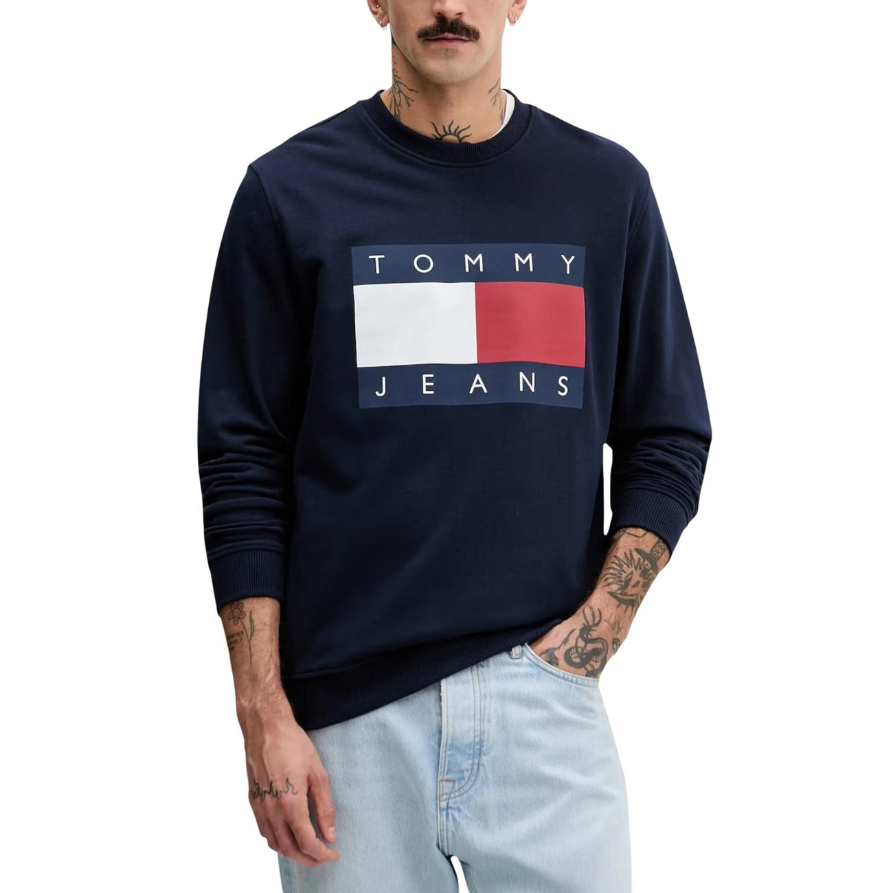 Felpa Tommy Jeans Iconic Flag; Cotone Felpato. Blu, maxi stampa logo frontale, vestibilità regular. Felpa uomo girocollo morbida e calda dal design iconico.