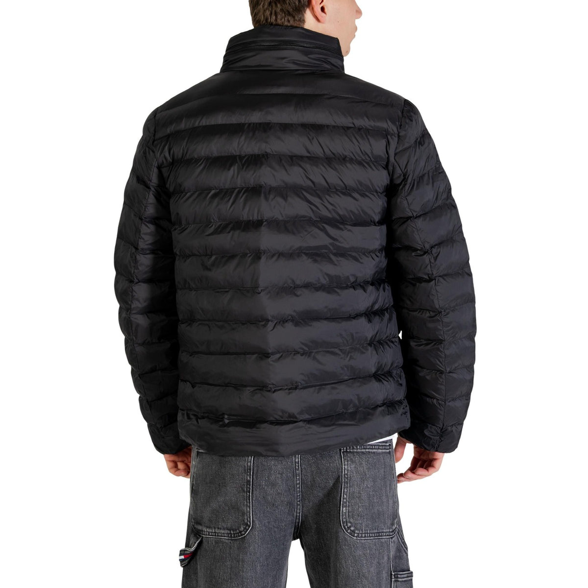 Piumino Calvin Klein Essentials; 100% Nylon Impermeabile. Imbottitura riciclata, cappuccio a scomparsa, fit regolare. Giacca uomo leggera, isolante e traspirante per la PE26. Colore nero vista posteriore