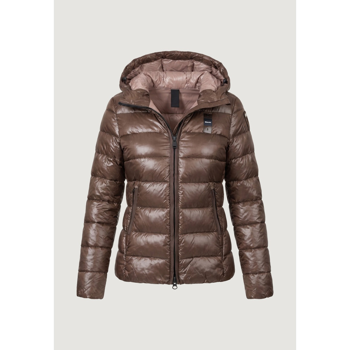 Piumino donna Blauer marrone Caroll 26WBLDC02070. Giubbotto corto da donna marrone trapuntato e sfiancato con cappuccio regolabile, zip a doppio cursore e logo Blauer sulla manica, giacca invernale calda e casual chic.