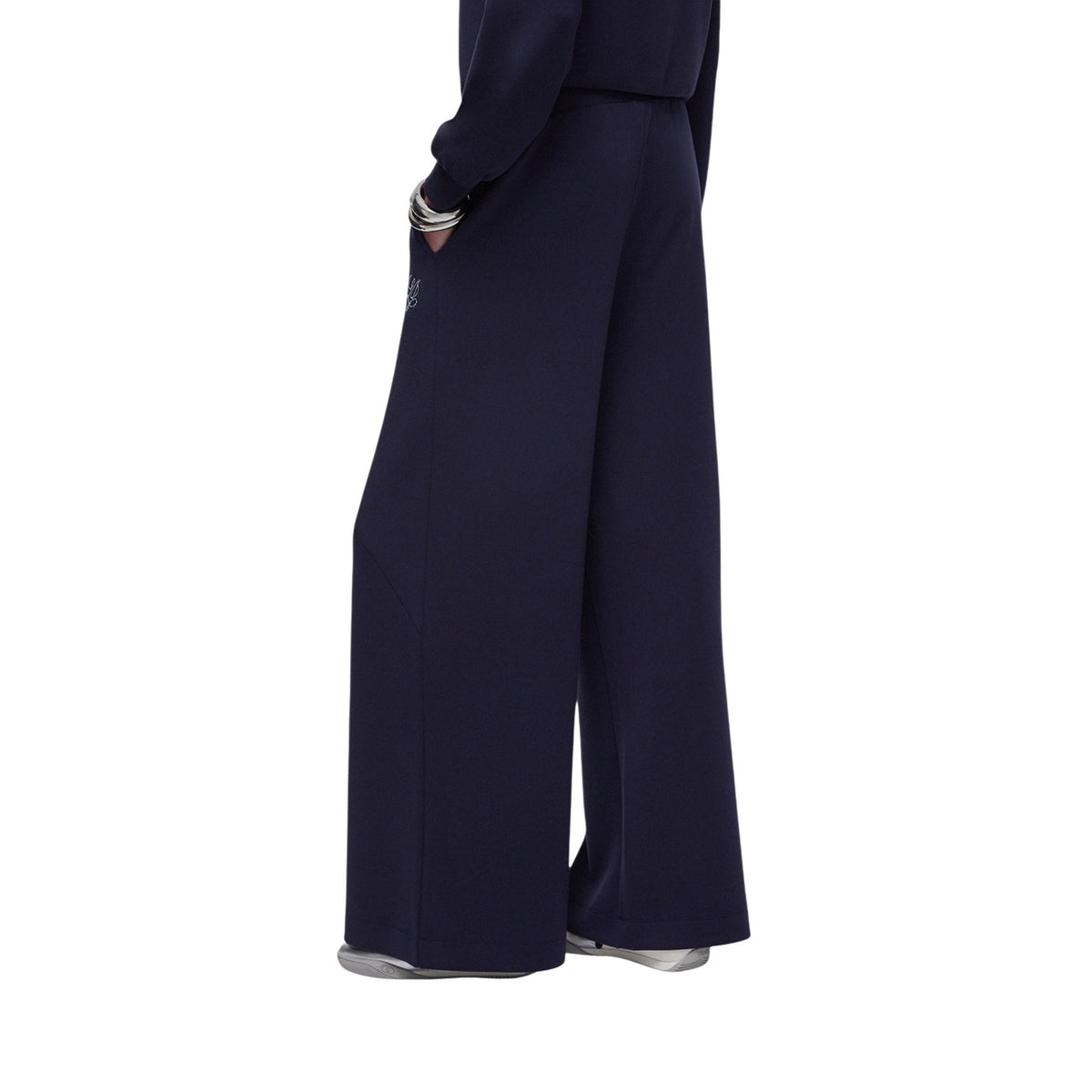 Liu Jo Scuba Flare Pants; tessuto neoprene leggero, vestibilità ampia, logo ricamato. Il pantalone sportivo elegante della linea eco-friendly Better. Colore blu scuro. Vista laterale