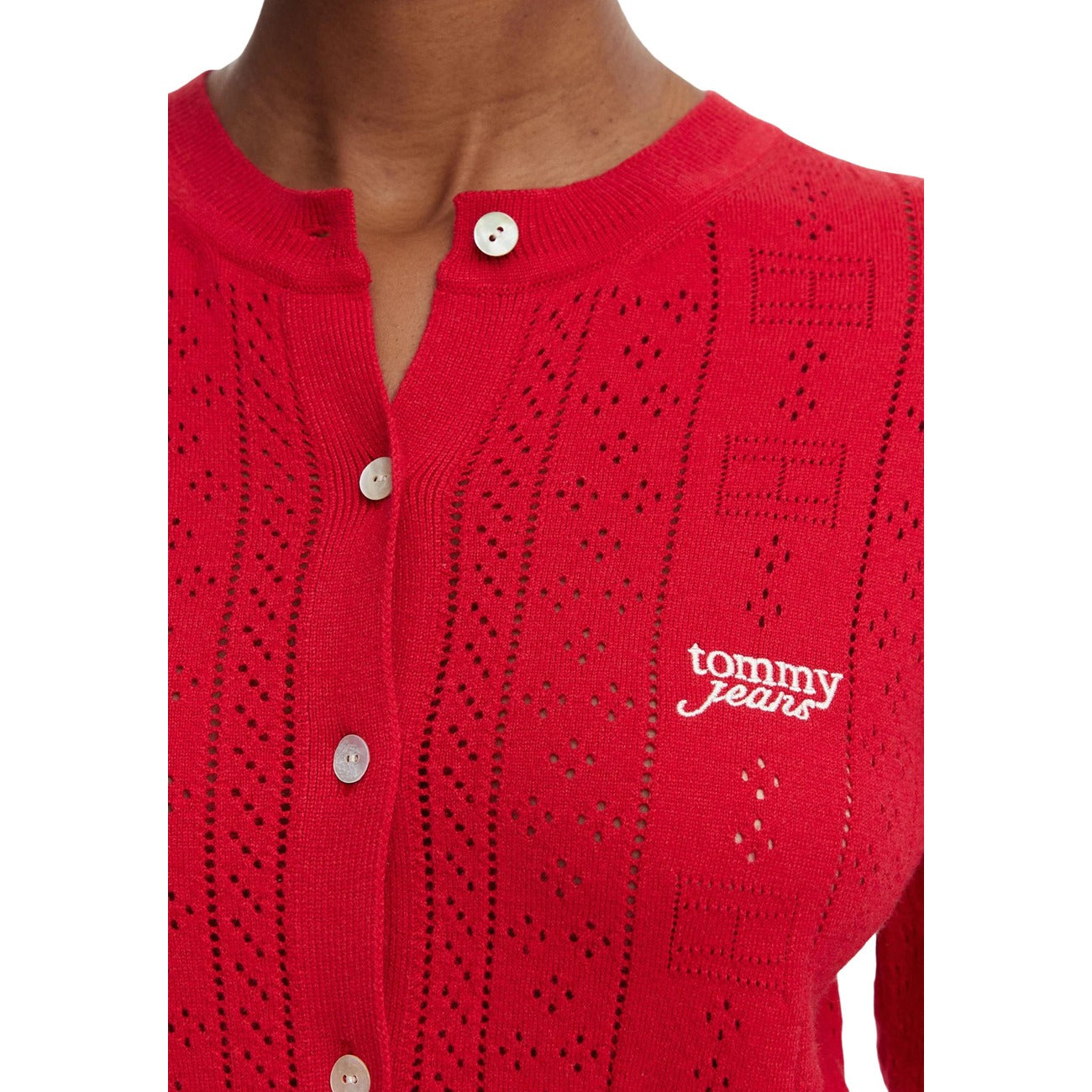 Cardigan Tommy Jeans donna rosso DW0DW22931 Amaryllis Red. Maglia aderente a maniche lunghe in tessuto traforato pointelle, scollo a girocollo, bottoni frontali, finiture smerlate e logo Tommy ricamato sul petto, abbigliamento donna autunno inverno.