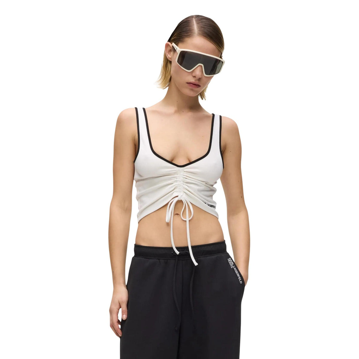 Canotta Cropped Coulisse; 62% Viscosa, 33% Poliammide, 5% Elastan. Scollo a V, profili contrasto, lunghezza regolabile. Top donna in maglia tecnica, traspirante e stretch per la PE26. Colore bianca