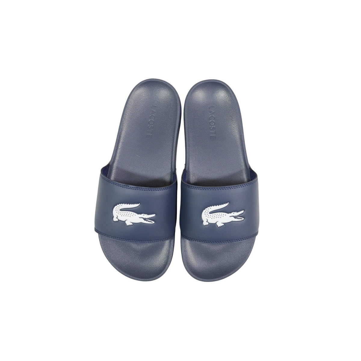 Ciabatte blu a fascia da uomo Lacoste Serve Slide 1.0 con logo del coccodrillo in rilievo sulla fascia ampia e suola ergonomica coordinata. Vista dall’alto
