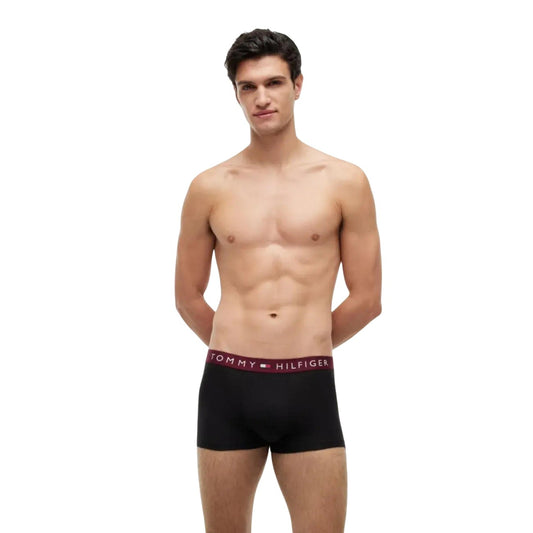 Pack 3 Boxer Trunk Tommy Hilfiger Signature; Nero. Cotone Organico Stretch, tecnologia antiumidità, elastico con logo ripetuto. Vestibilità aderente, supporto traspirante, qualità premium ecosostenibile. Fascia scritta rosso bordeaux